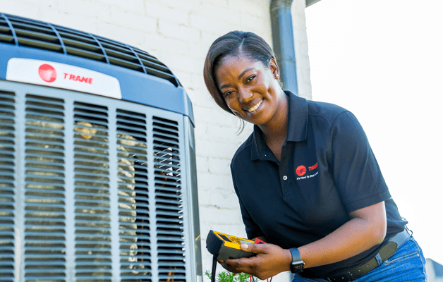 A Trane technician is inspecting a residential unit.