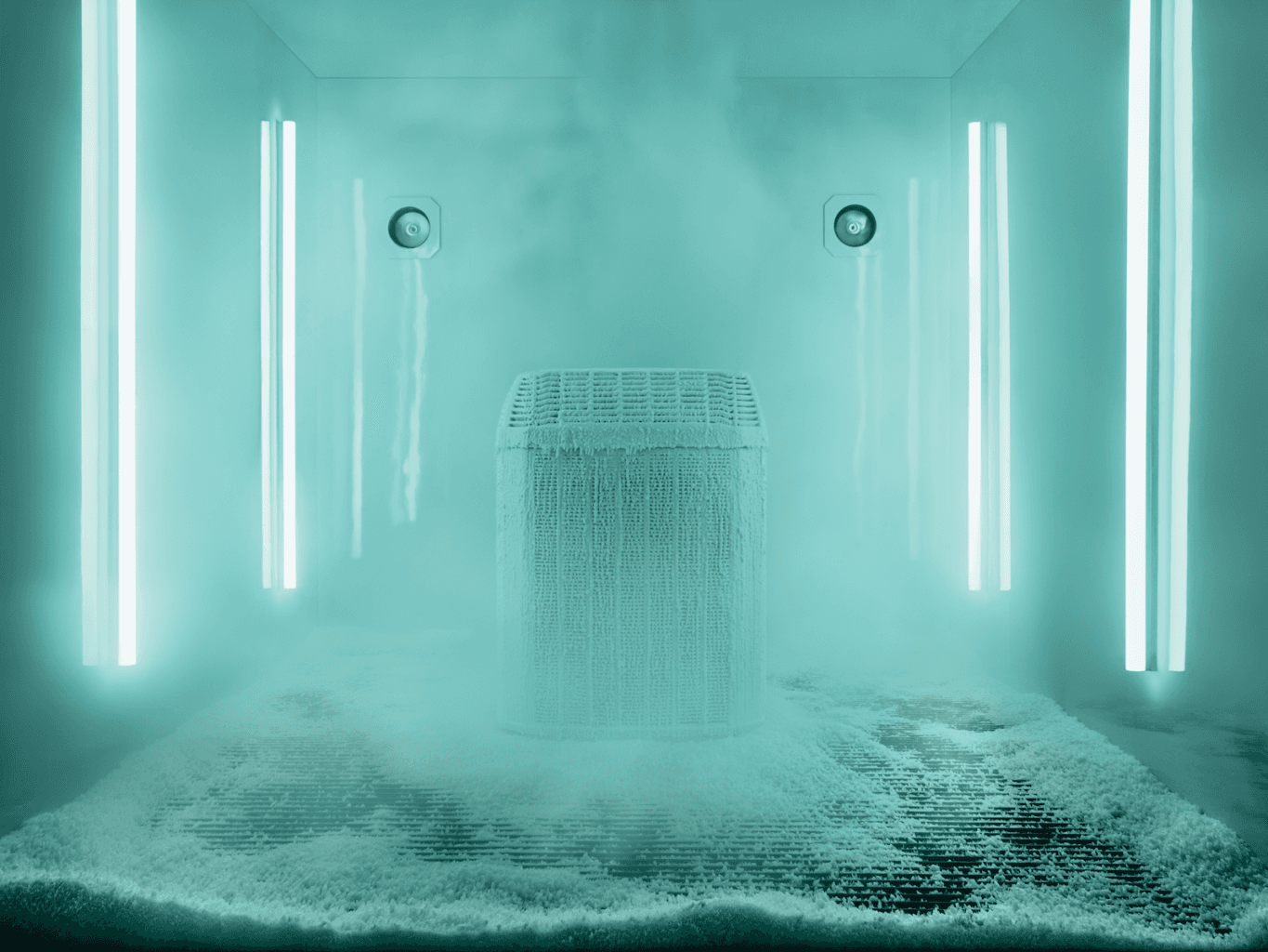 Trane air conditioner covered in ice is displayed inside a room with neon blue lighting.