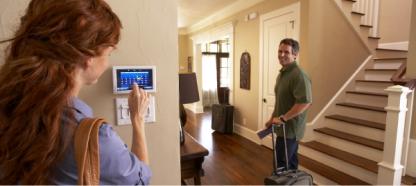 A couple sets their home thermostat before going on vacation.