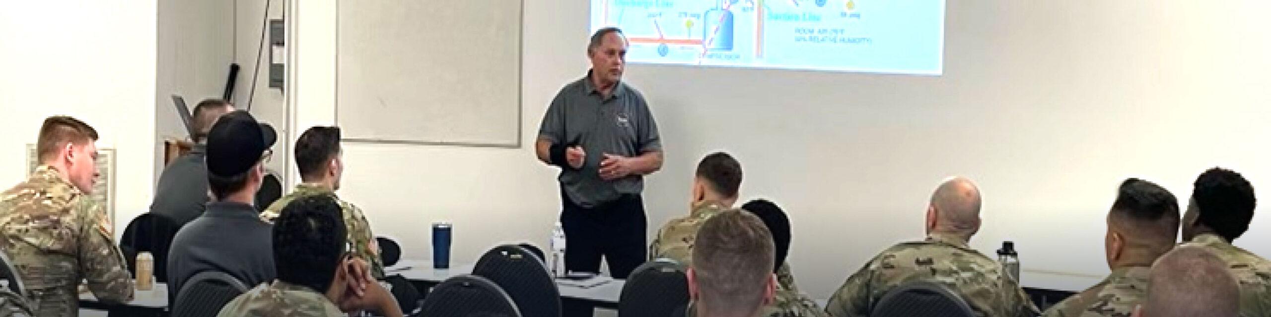 Military personnel are sitting in a classroom listening to a lecture.