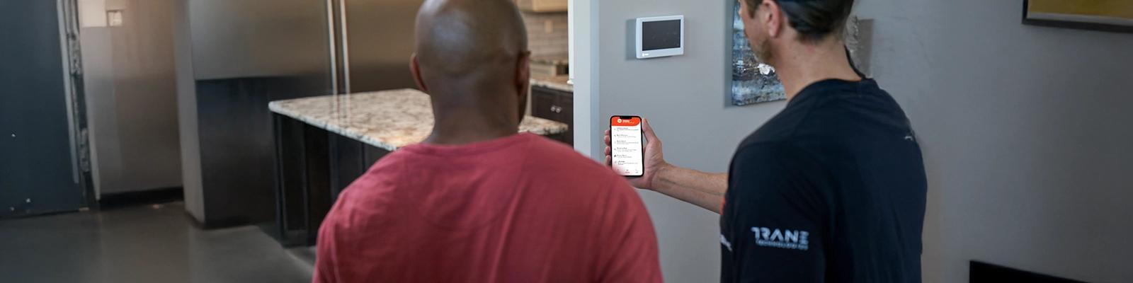HVAC Technician Holding a Smartphone with the HVAC Troubleshooting App Displayed
