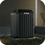 A Trane air conditioner is sitting outside of a home.